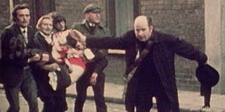 Father Edward Daly, waving a blood-stained white handkerchief as he escorts a mortally-wounded protester to safety during the events of Bloody Sunday (1972) in Derry, Northern Ireland. Shot by BBC journalist John Bierman [Wikipedia]