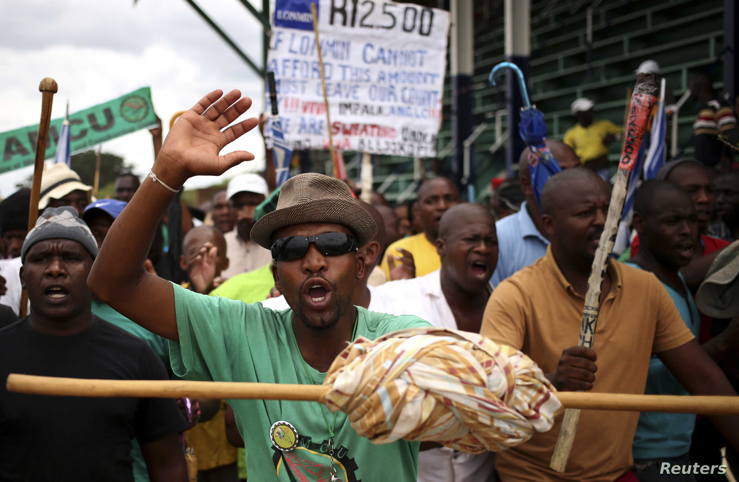 A miner gestures as they gather at Wonderkop stadium outside the Lonmin mine in Rustenburg, northwest of Johannesburg, Jan. 30th, 2014 [voanews.com]